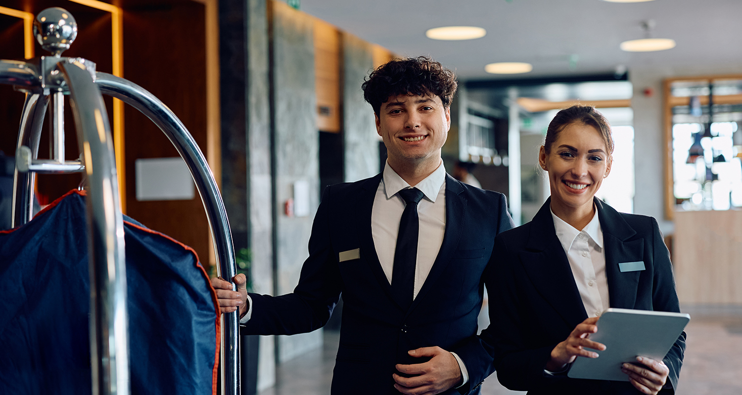 Portrait,Of,Happy,Hotel,Receptionists,In,A,Hallway,Looking,At