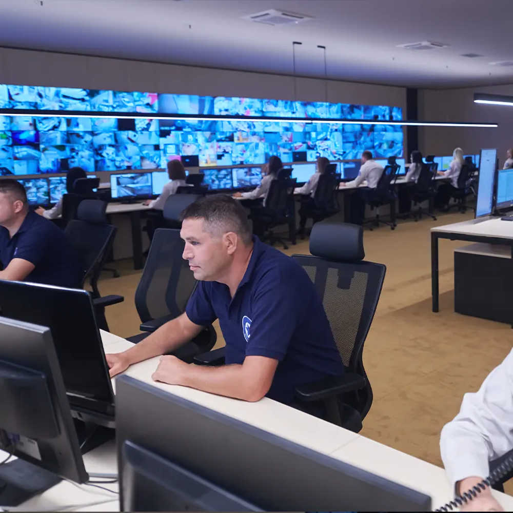 Professional security monitoring team tracking multiple camera feeds - Insyte Security centralized operations center intrusion detection